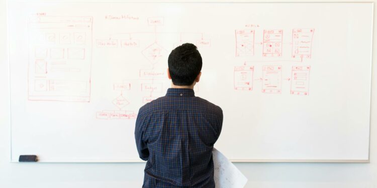 man standing infront of white board